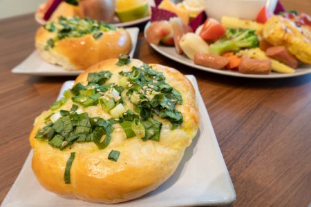Freshly baked bread topped with green onions and sesame seeds.