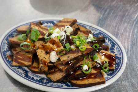 Téléchargez les photos : Assiette de tofu assaisonné avec sauce soja et oignons verts. - en image libre de droit