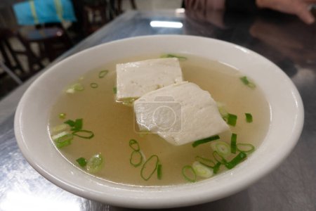 Cuenco de sopa de tofu con cebolla verde.