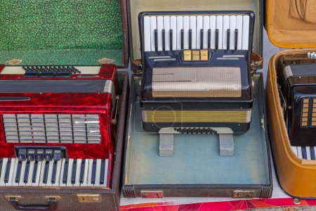 Gebrauchte Klavierakkordeon-Musikinstrumente im Koffer auf Flohmarkt