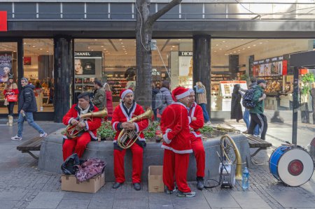 Foto de Belgrade, Serbia - December 31, 2022: Street Performers Musicians Dressed as Santa Claus During Christmas Festivity in Capital City Centre. - Imagen libre de derechos