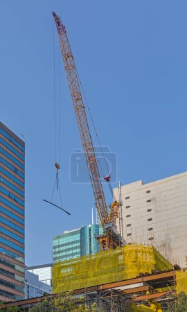 Photo for Lifting Crane at Top of Skyscraper Construction Site in Hong Kong - Royalty Free Image