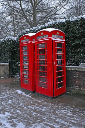 Foto de Dos cajas telefónicas rojas en la calle cubiertas de nieve en Londres Reino Unido - Imagen libre de derechos