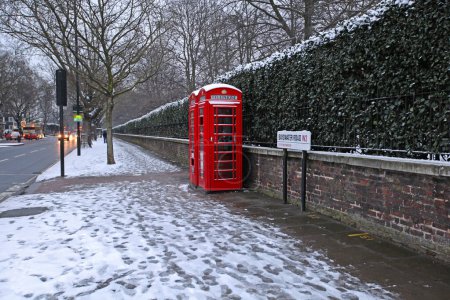 Téléchargez les photos : Londres, Royaume-Uni - 18 janvier 2013 : Des cabines téléphoniques rouges sur Bayswater Road couvertes de neige froide hiver dans la capitale. - en image libre de droit