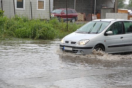 Téléchargez les photos : Voiture Conduite à travers la route inondée Catastrophe naturelle Inondations flash - en image libre de droit