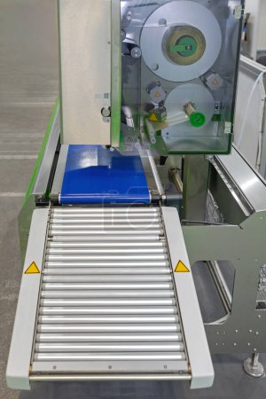 Foto de Rodillos transportadores en la línea de producción automatizada de la máquina etiquetadora en fábrica - Imagen libre de derechos