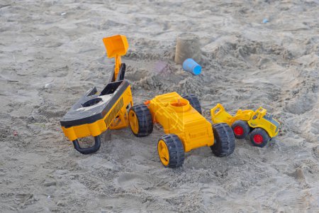 Photo for Yellow Construction Equipment Toys in Sand at Beach - Royalty Free Image