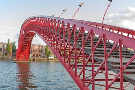 Photo for Amsterdam, Netherlands - May 17, 2018: Red Pyton Bridge Over Water Canal in East Amsterdam, Holland. - Royalty Free Image