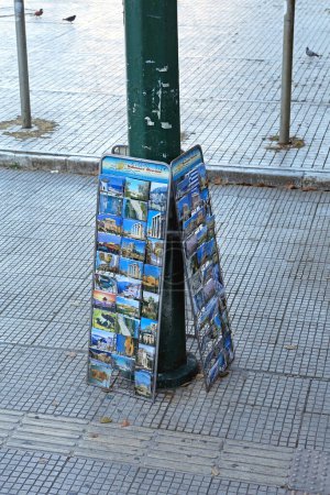 Foto de Atenas, Grecia - 04 de mayo de 2015: Tarjetas postales destacan recuerdos en la calle frente a la atracción turística en el centro de la ciudad. - Imagen libre de derechos
