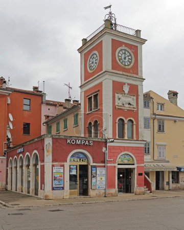 Foto de Rovinj, Croacia - 15 de octubre de 2014: Compass Travel Agency y Clock Bell Tower en Town Square. - Imagen libre de derechos