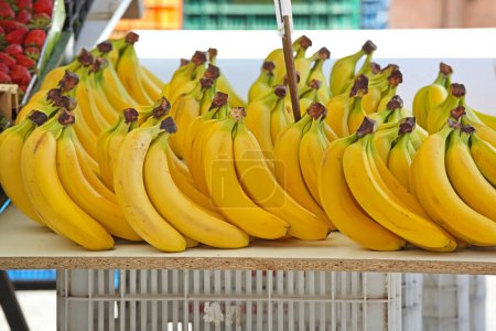Foto de Ramo de plátanos amarillos maduros en el estante de la tienda de comestibles - Imagen libre de derechos