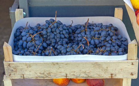 Foto de Fruta de la baya de uvas oscuras en jaula de madera en el mercado de agricultores - Imagen libre de derechos
