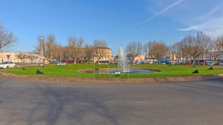 Foto de Arles, Francia - 29 de enero de 2016: Fuente de géiser de agua en la rotonda Place Lamartine en el soleado día de invierno. - Imagen libre de derechos