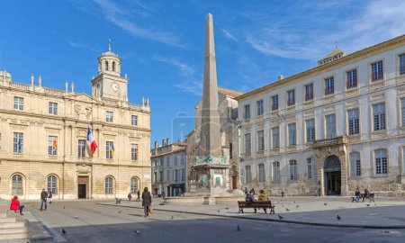 Foto de Arles, Francia - 29 de enero de 2016: Monumento histórico del Obelisco Romano y Ayuntamiento en la Plaza de la República Día soleado de invierno. - Imagen libre de derechos