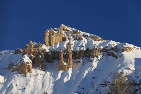 Foto de Altos picos cubiertos de nieve en el norte del Líbano con rocas únicas y un crucifijo en la parte superior, - Imagen libre de derechos