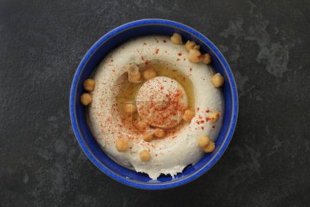 Photo for A Lebanese traditional plate of hummus with olive oil, chickpeas, and a chili flakes. - Royalty Free Image