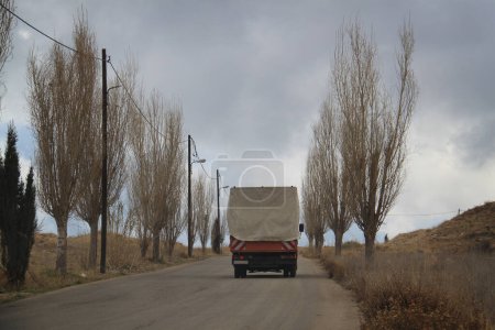 Téléchargez les photos : Une camionnette conduisant par une journée froide sur une route désolée. - en image libre de droit