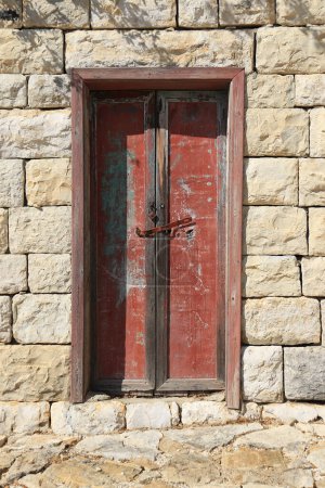 Téléchargez les photos : Une porte fermée en bois avec peeling peinture rouge. - en image libre de droit