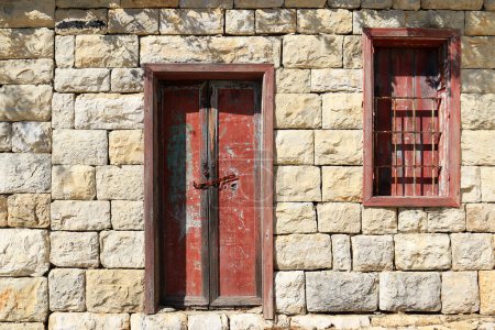 Téléchargez les photos : Une porte et une fenêtre fermées en bois avec peinture rouge épluchante. - en image libre de droit