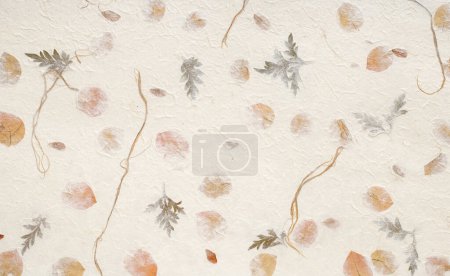 Photo for Handcrafted off white paper background embedded with dried green and gold leaves and a rough texture - Royalty Free Image