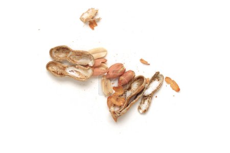 Photo for A couple of broken peanut shells, bits of shell and peanuts viewed from above,  symbolizing low pay. Isolated on white with Drop Shadow - Royalty Free Image