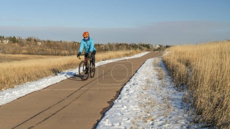 winter afternoon on a biking trail with a senior cyclist riding a gravel bike - Cathy Fromme Prairie Natural Area in Fort Collins, Colorado
