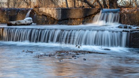 Téléchargez les photos : Eau en cascade sur un barrage de dérivation sur la rivière Poudre avec paysages automnaux, nature et concept industriel - en image libre de droit