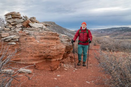 Foto de Senderista masculino senior es mochilero con bastones de trekking en Colorado estribaciones en el paisaje de otoño - Imagen libre de derechos