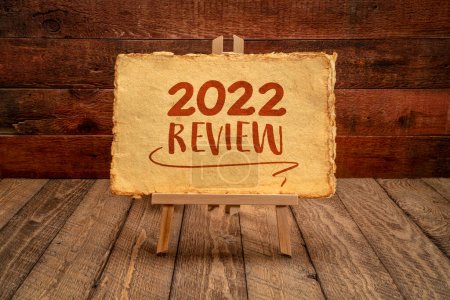Photo for 2022 year review - easel sign with antique paper against rustic wood, end of year business concept - Royalty Free Image