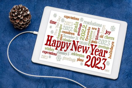 Foto de Tarjeta de felicitación Feliz Año Nuevo 2023 - nube de palabras en una tableta digital con un código decorativo de pino helado - Imagen libre de derechos