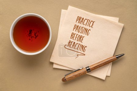Téléchargez les photos : Pause pratique avant de réagir - note inspirante sur une serviette avec une tasse de thé, concept de communication et de développement personnel - en image libre de droit