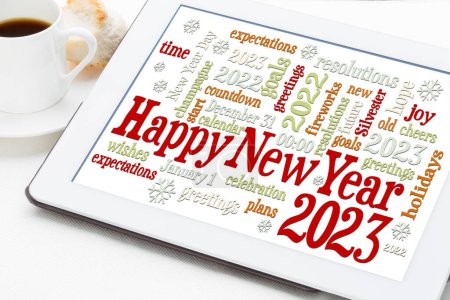 Foto de Tarjeta de felicitación Feliz Año Nuevo 2023 - nube de palabras en una tableta digital con una taza de café - Imagen libre de derechos