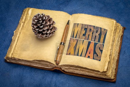 Photo for Merry Xmas (Christmas) greetings or wishes - word abstract in vintage letterpress wood type blocks in a retro journal, winter holidays banner - Royalty Free Image