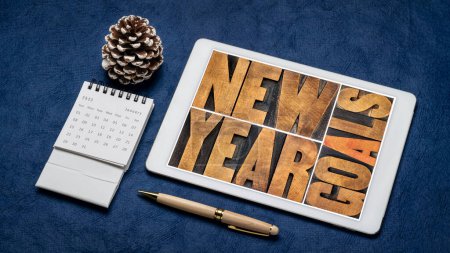 Foto de Objetivos de Año Nuevo - concepto de resolución y fijación de objetivos - palabra abstracta en tipografía vintage tipo madera en una tableta digital - Imagen libre de derechos
