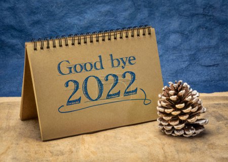 Téléchargez les photos : Au revoir 2022 - note dans un carnet en spirale avec un cône décoratif givré, passant concept de l'ancienne année - en image libre de droit