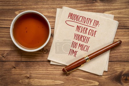 Téléchargez les photos : Conseil de productivité, ne vous donnez jamais trop de temps - conseils inspirants ou rappel, écriture sur une serviette avec une tasse de thé - en image libre de droit