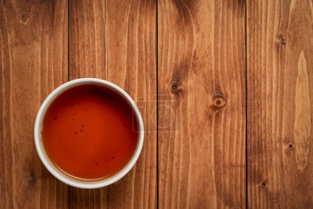 Foto de Vista superior de la taza de té rojo rooibos en la mesa de madera - Imagen libre de derechos