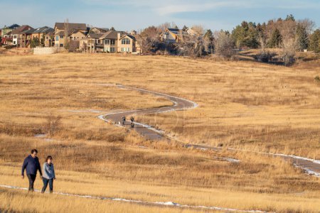 Téléchargez les photos : Fort Collins, CO, USA - 30 janvier 2022 : Familles profitant d'un après-midi d'hiver calme et chaud sur une piste cyclable à Cathy Fromme Prairie Natural Area dans les contreforts du Colorado. - en image libre de droit