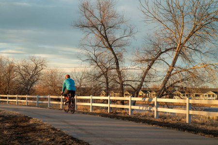 männlicher Radfahrer fährt im Herbst oder Winter auf einem der zahlreichen Radwege im Norden Colorados - dem Poudre River Trail in der Nähe von WIndsor