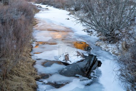 Téléchargez les photos : Frozen creek with sunset reflections - North Fork of Cache la Poudre River in Eagle Nest Open Space in northern Colorado - en image libre de droit