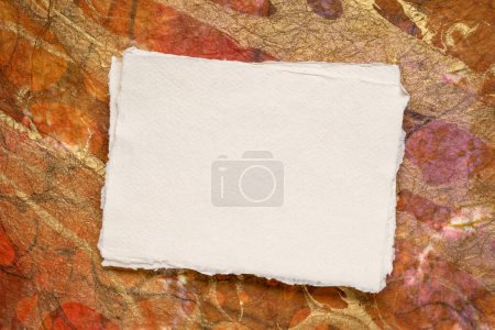 Foto de Small sheet of blank white Khadi rag paper from South India against metallic marbled paer - Imagen libre de derechos