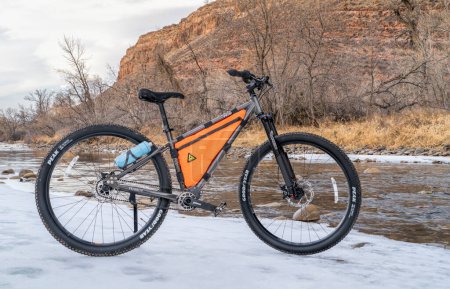 Photo for Fort Collins, CO, USA - January 16, 2023: 600x Priority adventure mountain bike with carbon fiber-reinforced drive belt and enclosed Pinion gearbox on the river shore in winter. - Royalty Free Image