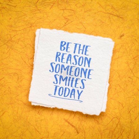 Téléchargez les photos : Be the reason someone smiles today -  inspirational advice or reminder - handwriting on a handmade paper, kindness and positivity concept - en image libre de droit