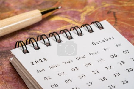 Téléchargez les photos : October 2023 - closeup of a small desktop calendar with a pen, time and business concept - en image libre de droit