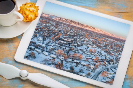 Téléchargez les photos : Winter sunrise over residential area of Fort Collins and Rocky Mountains foothills in Colorado, aerial image display on a tablet - en image libre de droit