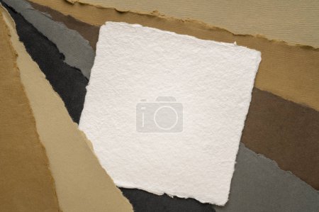 Foto de Small square sheet of blank white Khadi paper against paper abstract in earth colors - Imagen libre de derechos