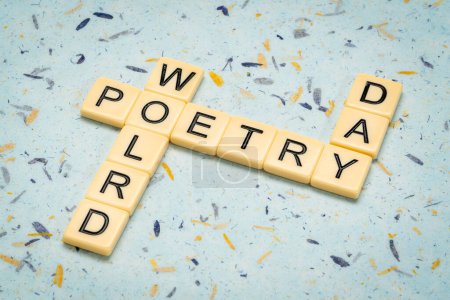 Photo for World Poetry Day - crossword  against handmade art paper, reminder of annual cultural event, March 21 - Royalty Free Image