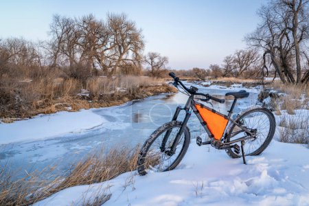 Photo for Mountain bike with a frame bag on a shore of the Poudre River near Greeley, Colorado, in winter scenery - Royalty Free Image