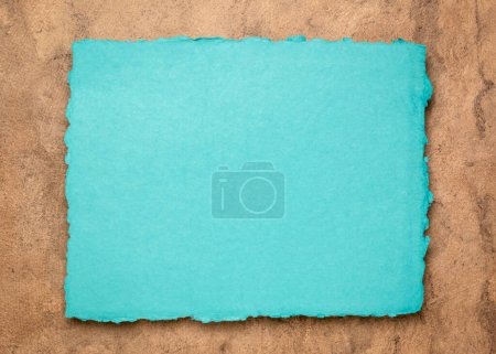 Foto de Abstracto azul y marrón, una hoja de papel de trapo en blanco contra papel de corteza texturizado, espacio para copiar - Imagen libre de derechos