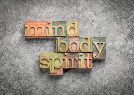 Körper, Geist und Seele - Worte im Holzbuchdruck gegen strukturiertes Papier, ganzheitliches Wellness- und Lifestylekonzept